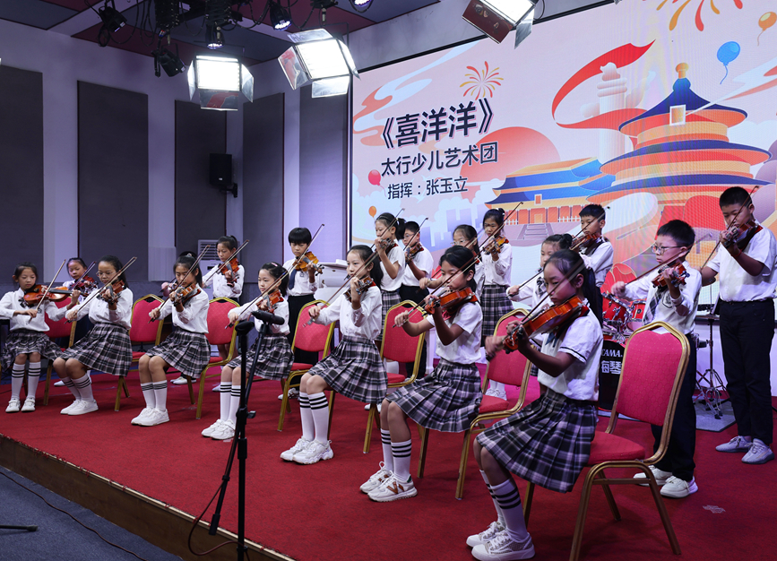 河北省邢台市信都区太行少儿艺术团的小提琴手在表演小提琴合奏，和专业乐团“切磋”演奏。 樊青芳摄