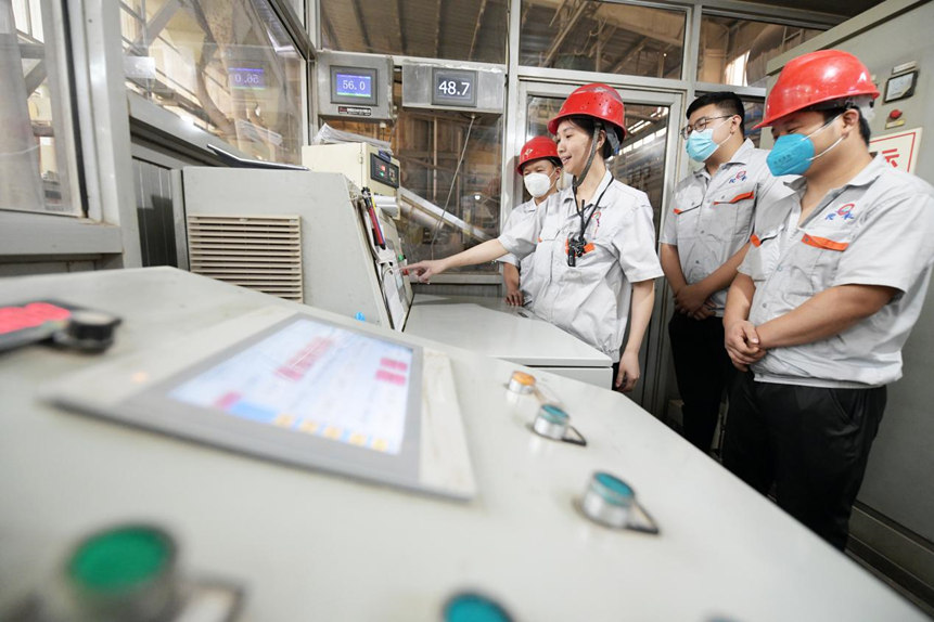 在文安县左各庄镇廊坊民丰木业有限公司生产车间,该厂技术人员向新员工讲解铺装室操作流程。 高丹钰摄