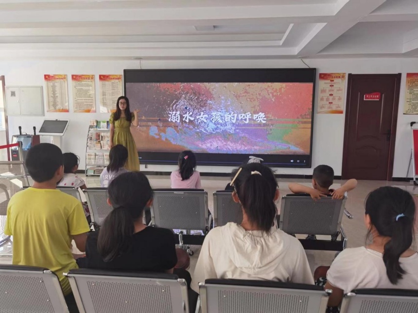 志愿者在为孩子们讲解安全自救知识。 戴敏摄
