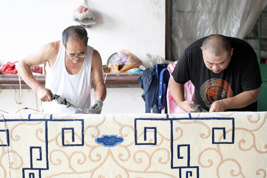 在文安县孙氏镇一家宫毯制作工坊，片剪工人正在运用片、剪、投等不同工艺和技巧，对地毯半成品进行整理。 郑佳庆摄