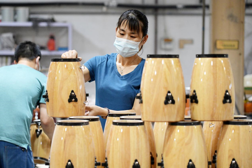 在文安县新镇镇一家乐器生产企业加工车间，工人正在码放儿童康佳鼓。 高丹钰摄