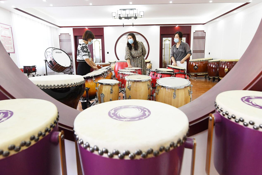 在文安县新镇镇一家乐器生产企业展示厅，工人向顾客介绍五音排鼓。 高丹钰摄