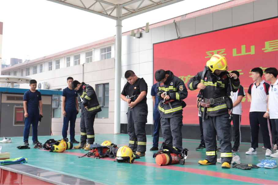 消防救援大隊隊員在為學生培訓防火服知識。 李玉虎攝