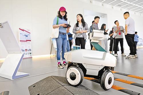 7月19日，参观人员在雄安新区科创中心中试基地（一期）体验操作轮式智能巡检机器人。河北日报记者 张 昊摄