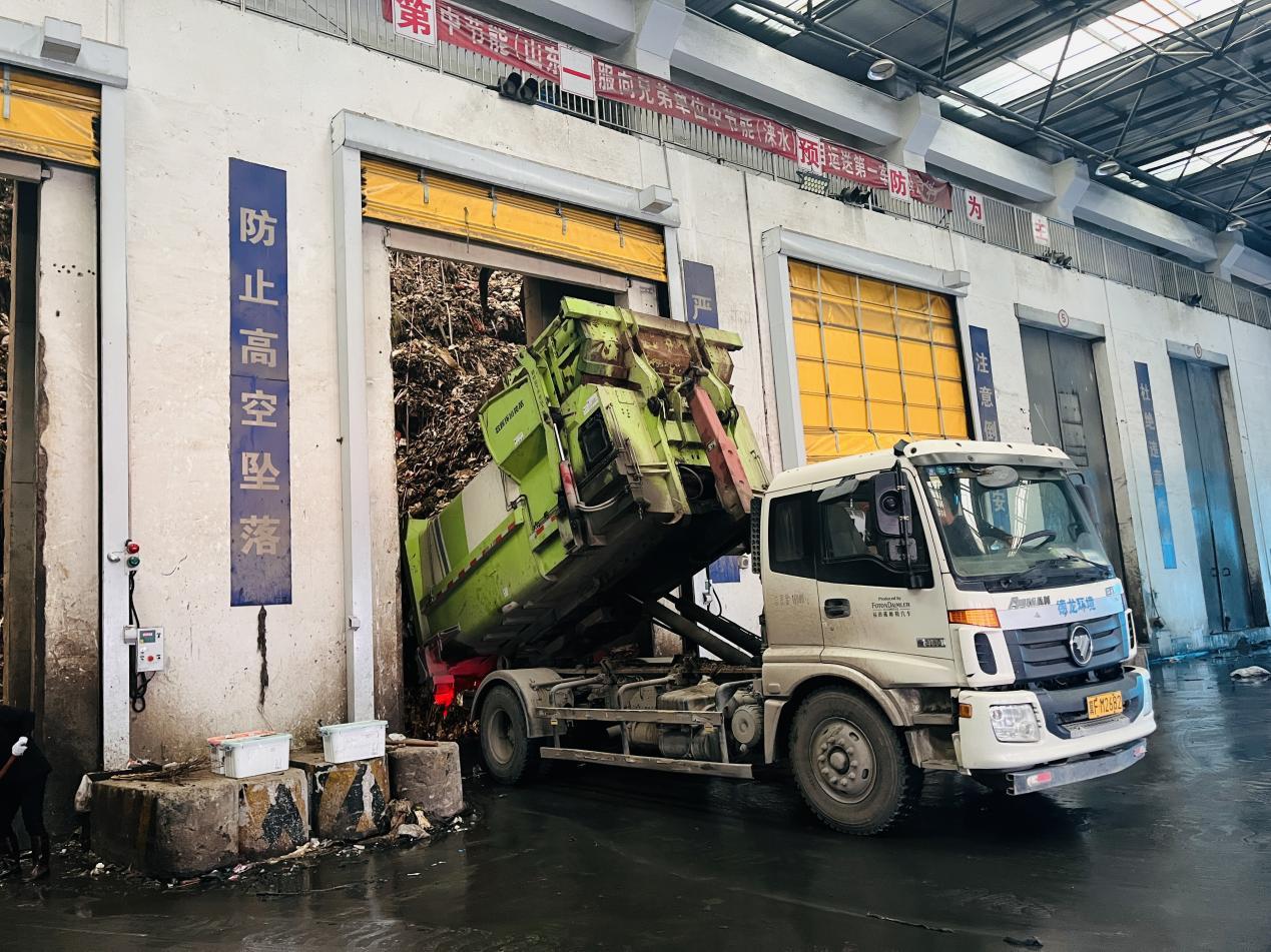 在中節能淶水公司卸料平台，環衛工人正駕駛垃圾轉運車將垃圾傾倒進全封閉垃圾倉內。 李金璐攝