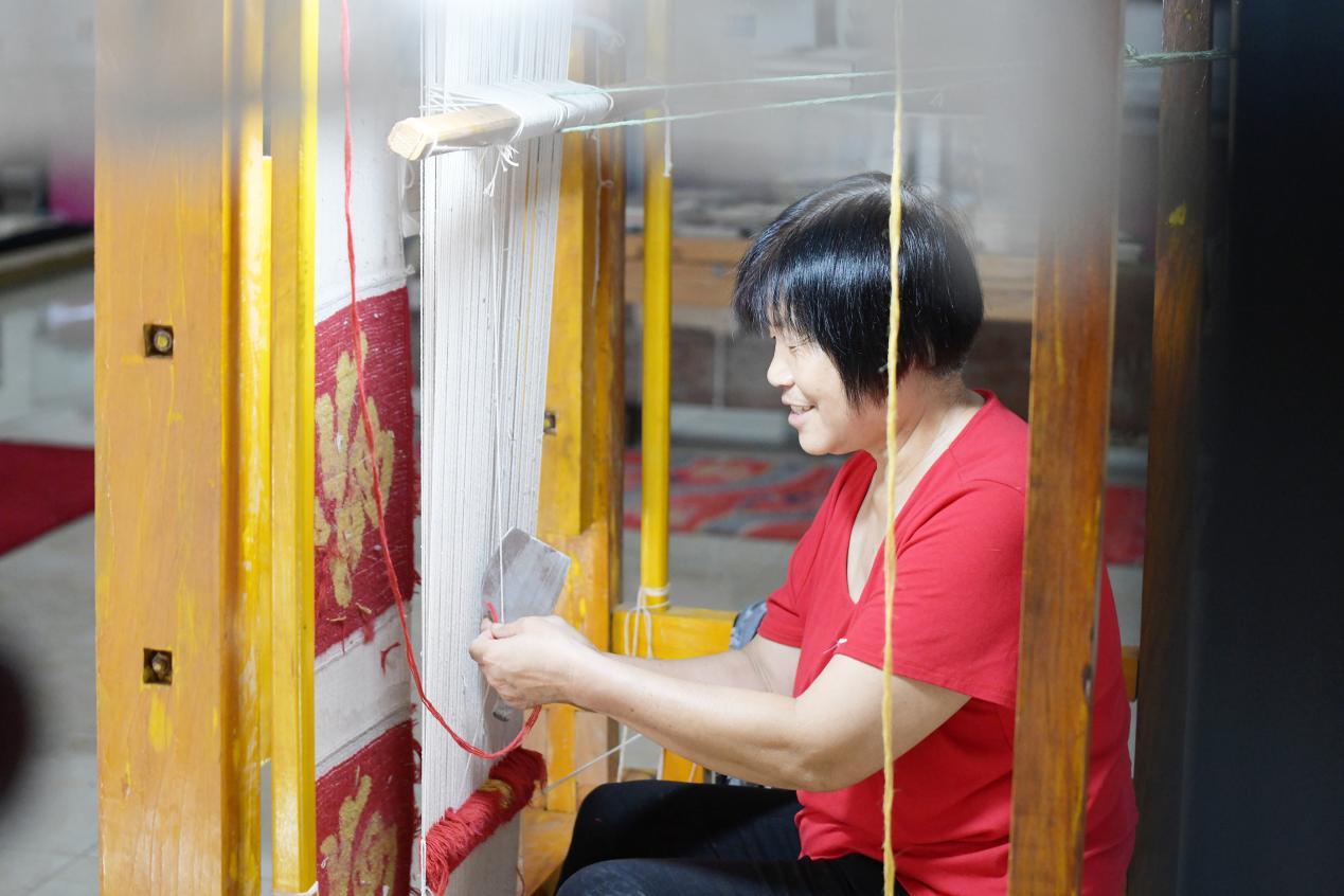 在文安县孙氏镇一家宫毯制作工坊，宫毯织造艺人正在织造宫毯。 高丹钰摄