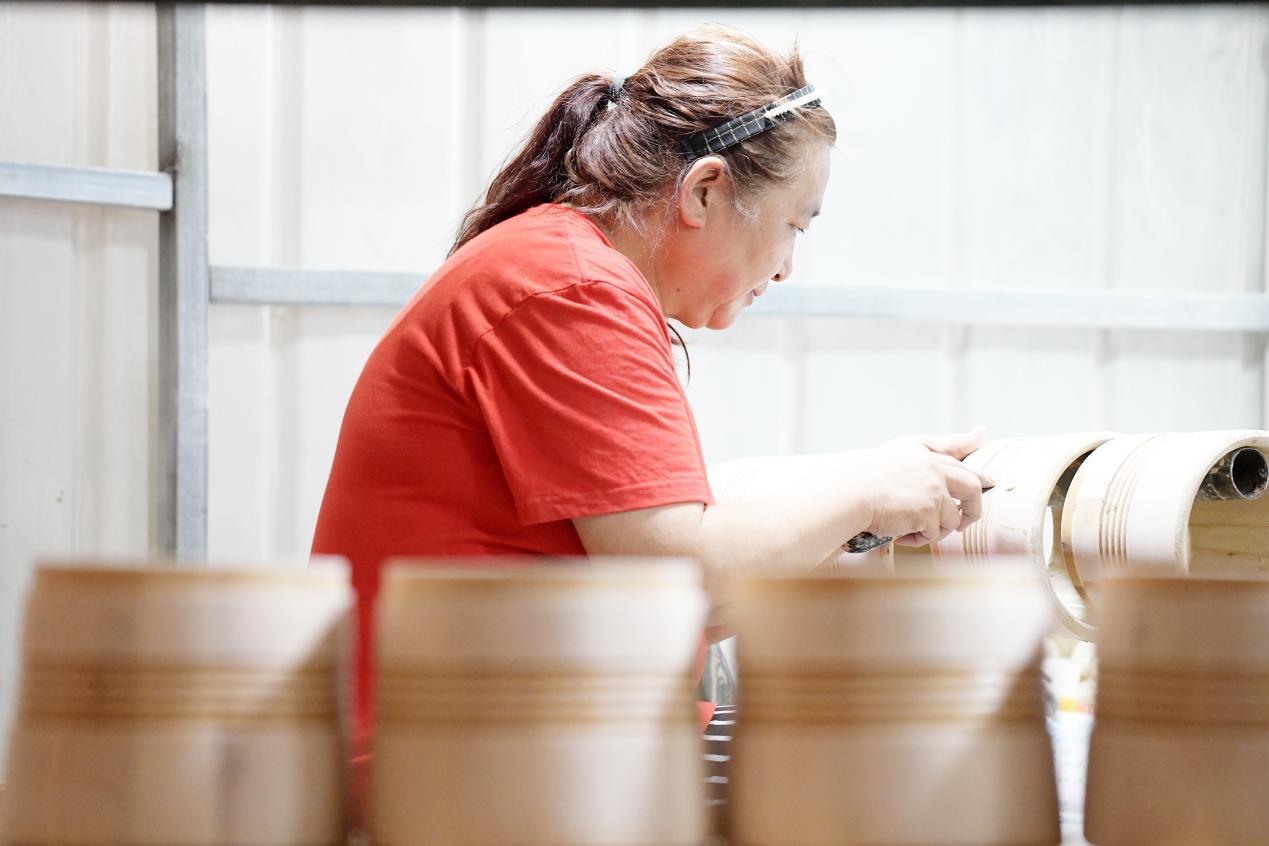 在文安县新镇镇一家乐器生产企业加工车间，工人正在打磨邦戈鼓。 高丹钰摄