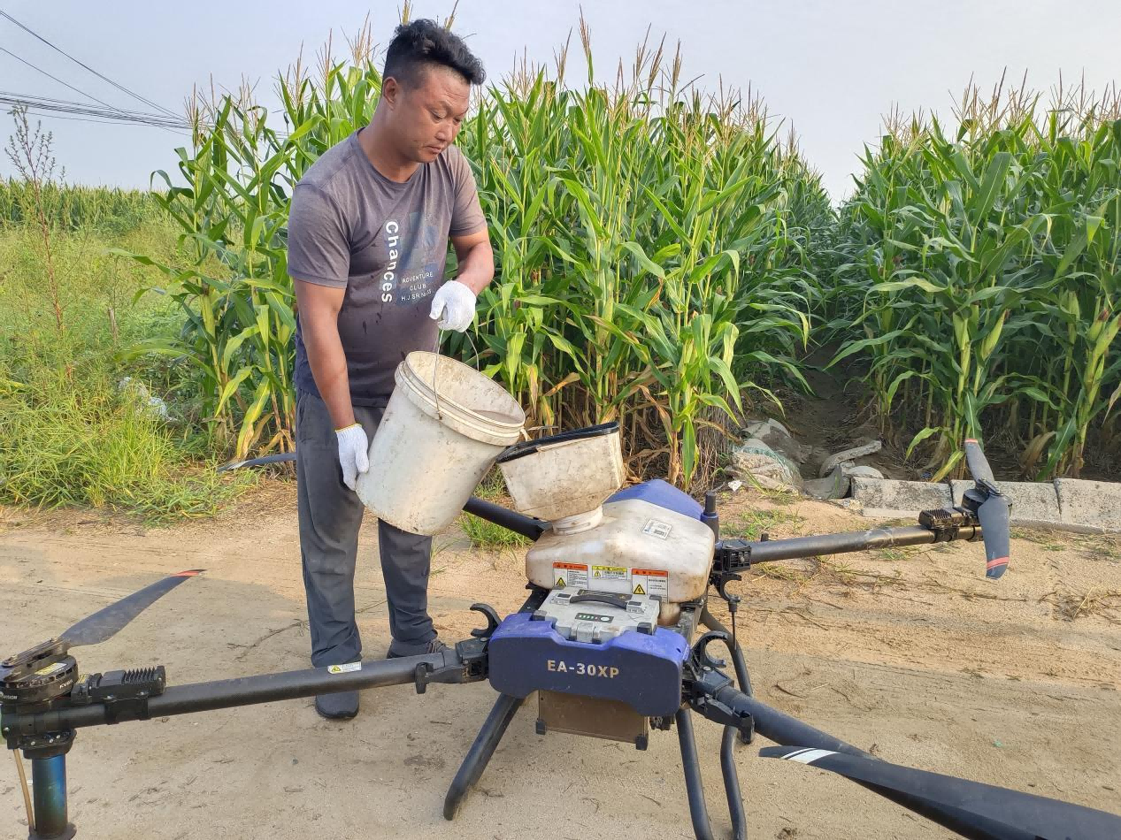 農技人員為無人機裝藥。 王雙龍攝