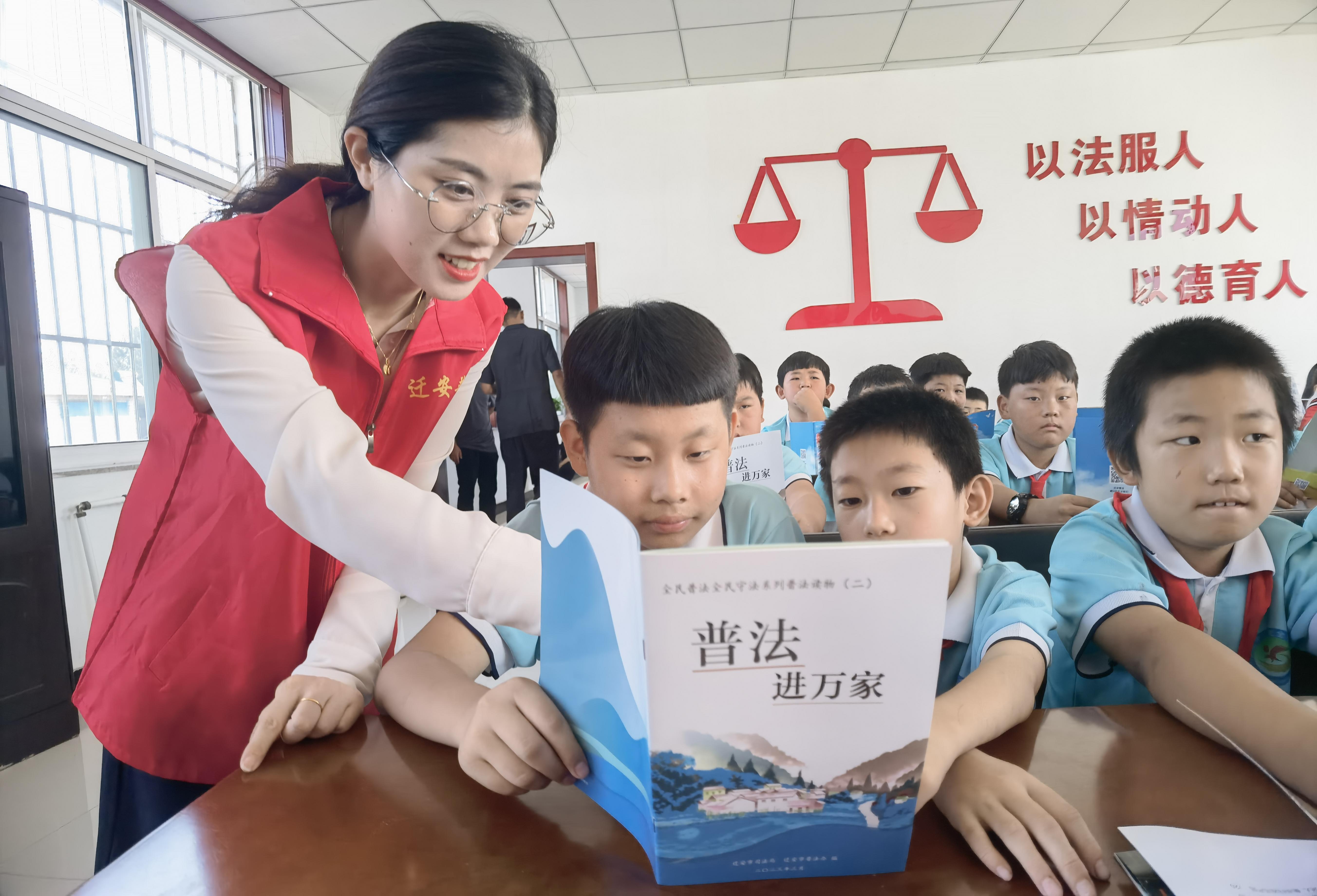 普法工作者為小學生講解法律知識。 商立超攝