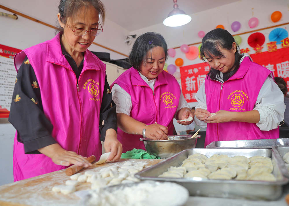 海港区新闻里社区志愿者在包饺子。 曹建雄摄