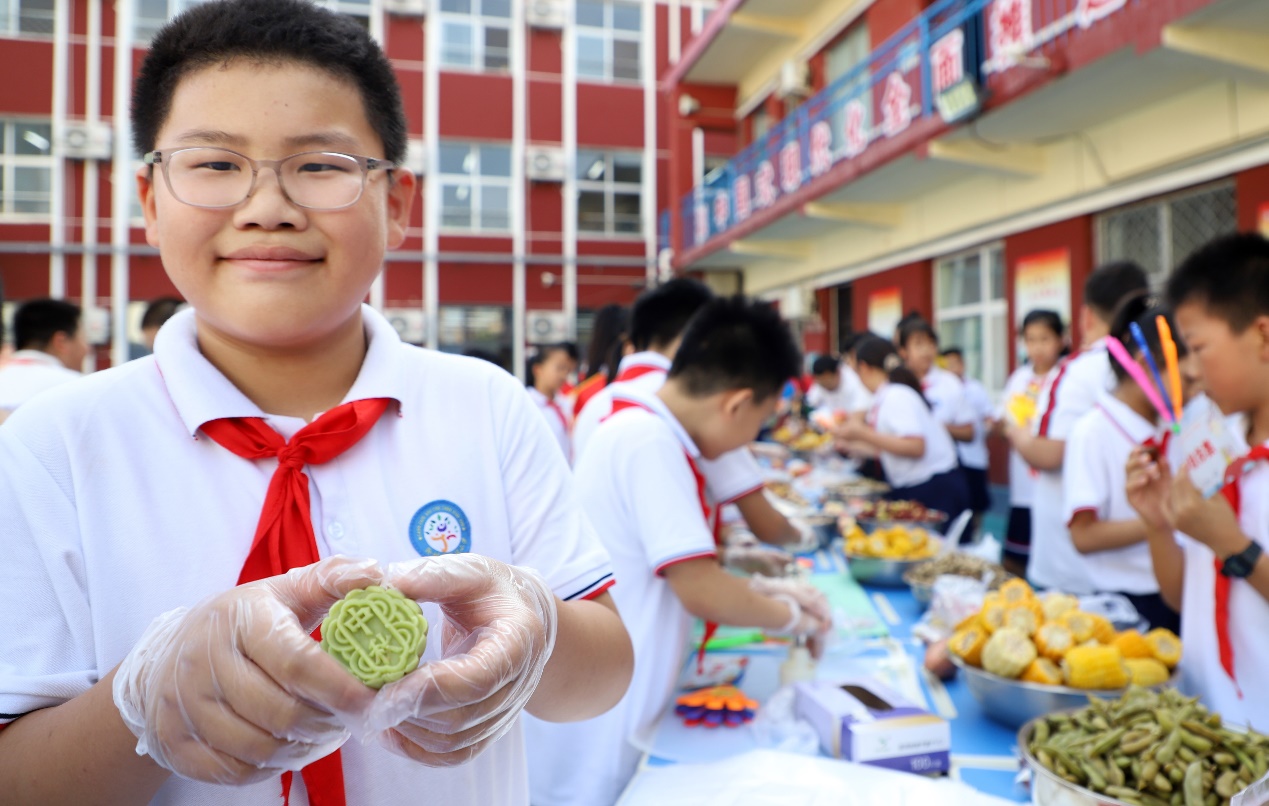 一个孩子展示他制作的月饼。 魏志广摄