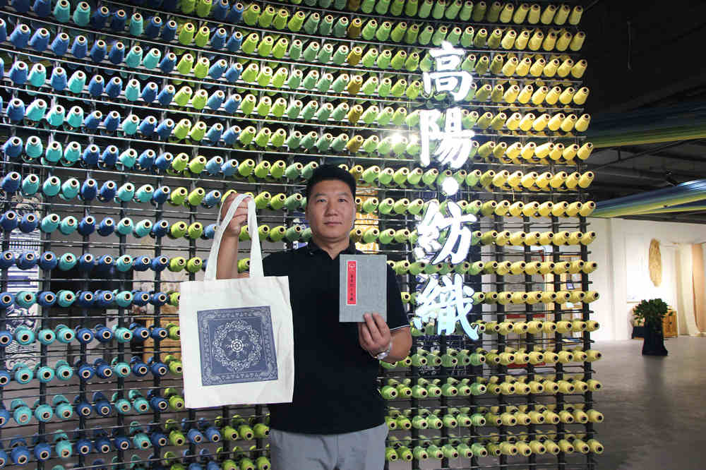 游客展示打卡获赠的草木染包。 甄亚军摄