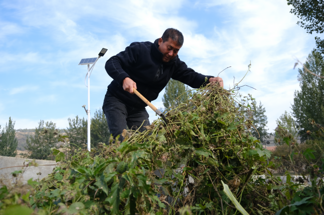 在淶源縣北石佛鎮石道溝村,村民們清理路標雜草。 邸威攝