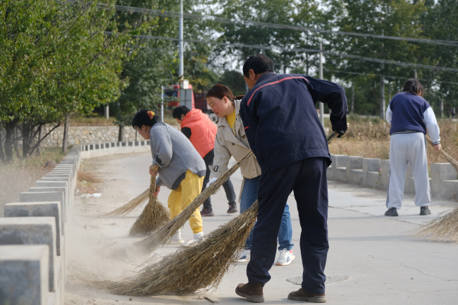 在淶源縣北石佛鎮石道溝村,廣大黨員干部與村民們齊動手清理衛生死角。 邸威攝