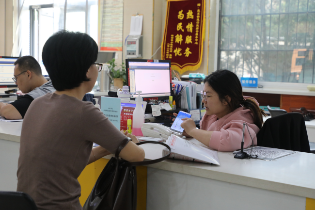 橋西區苑東街道工作人員指導企業負責人通過手機“冀時辦”平台線上辦理業務。 吳夢瑩攝