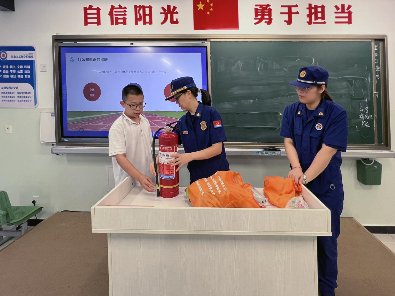 消防宣传员为学生讲解灭火器的使用。 刘月摄