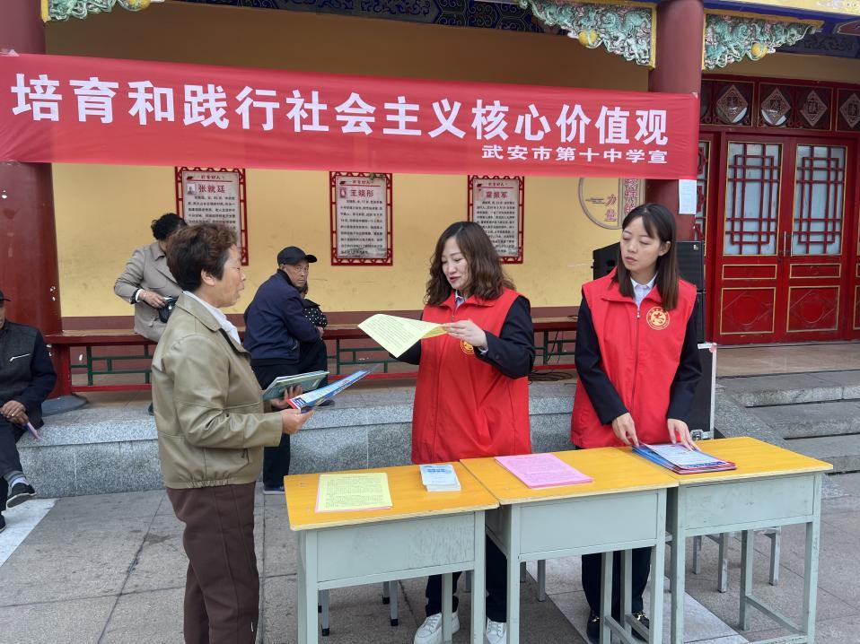 武安第十中學教師向群眾普及文明城市知識。 李麗娟攝