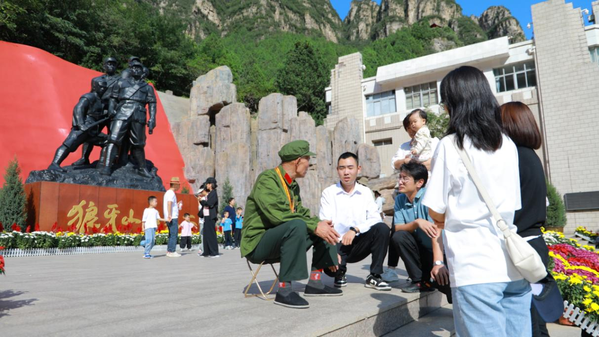 10月15日，退伍老兵李金玉為游客講述紅色事跡，共同感悟革命先烈不畏犧牲、奮斗不屈的偉大精神。 左小東攝