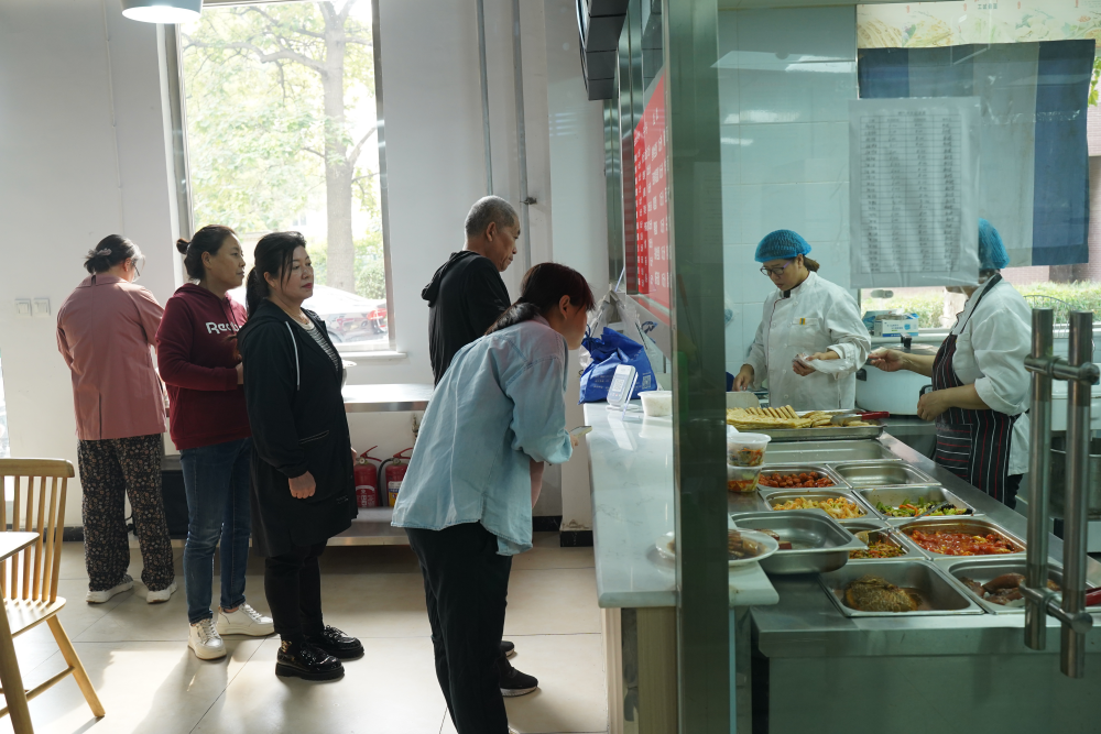 石家庄市桥西区仓北社区惠民食堂，临近中午居民前来就餐。 吴梦莹摄