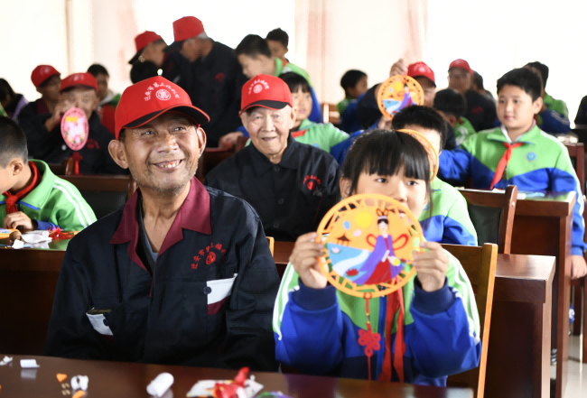 10月19日，在遷安市民政局第三福利院內，孩子們正在和老人們一起制作重陽節手工作品。 鄒雅婕攝