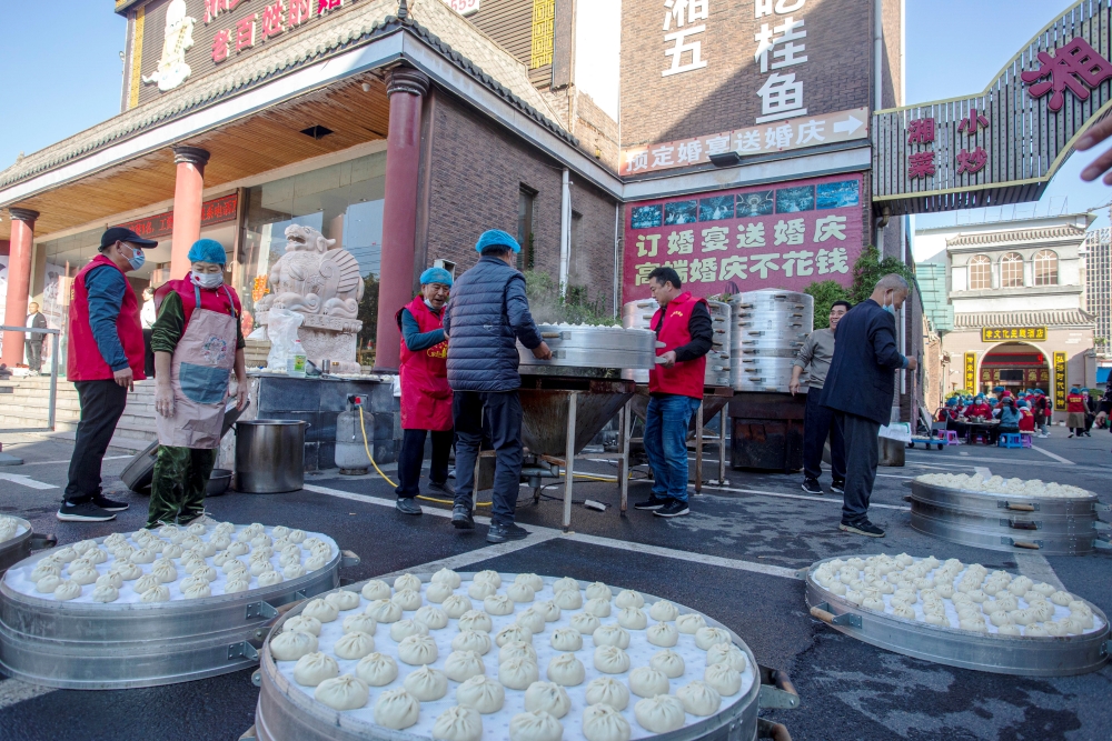 河北省邯鄲市復興區彭家寨鄉王郎社區開展“情暖社區 愛在重陽”百叟宴系列孝老敬老活動，愛心志願者將包好的包子上籠蒸。 聶長青攝