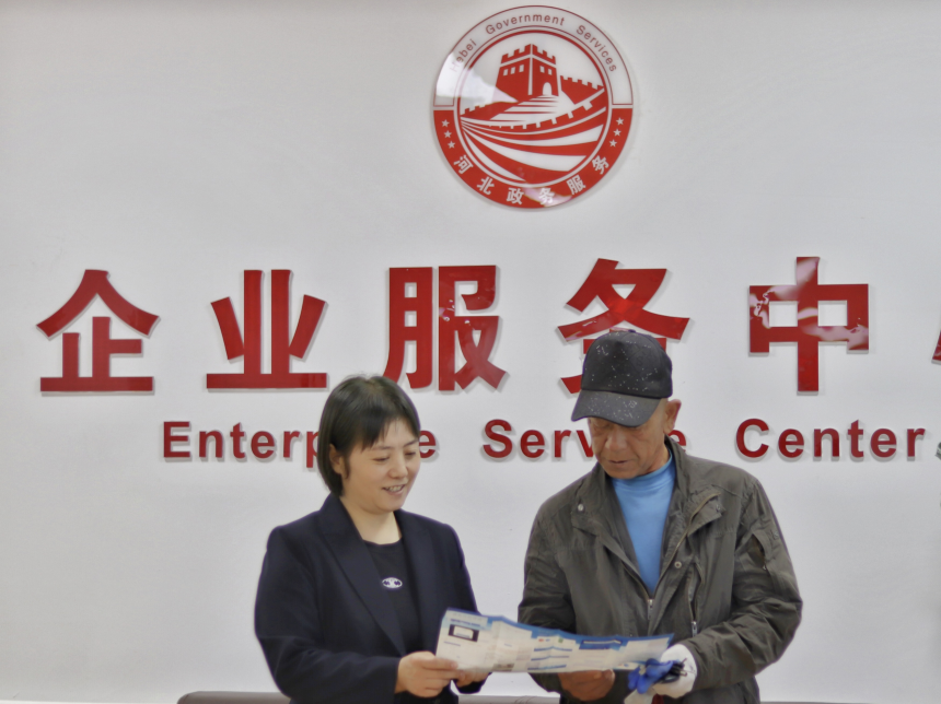 审批局帮办工作人员告知老人申办材料。 张光伟摄