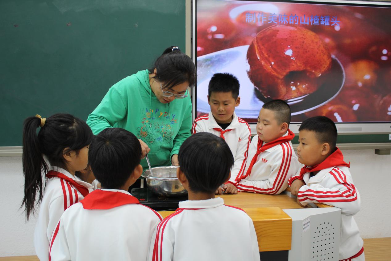 在老师们的帮助下，丰南区岔河中心小学学生们制作了美味的山楂罐头。 王秋雅摄