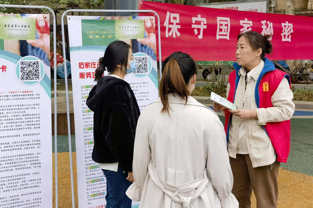 桥西区友谊街道五十四所社区的居民向工作人员询问人才政策的详细内容。 李莉摄