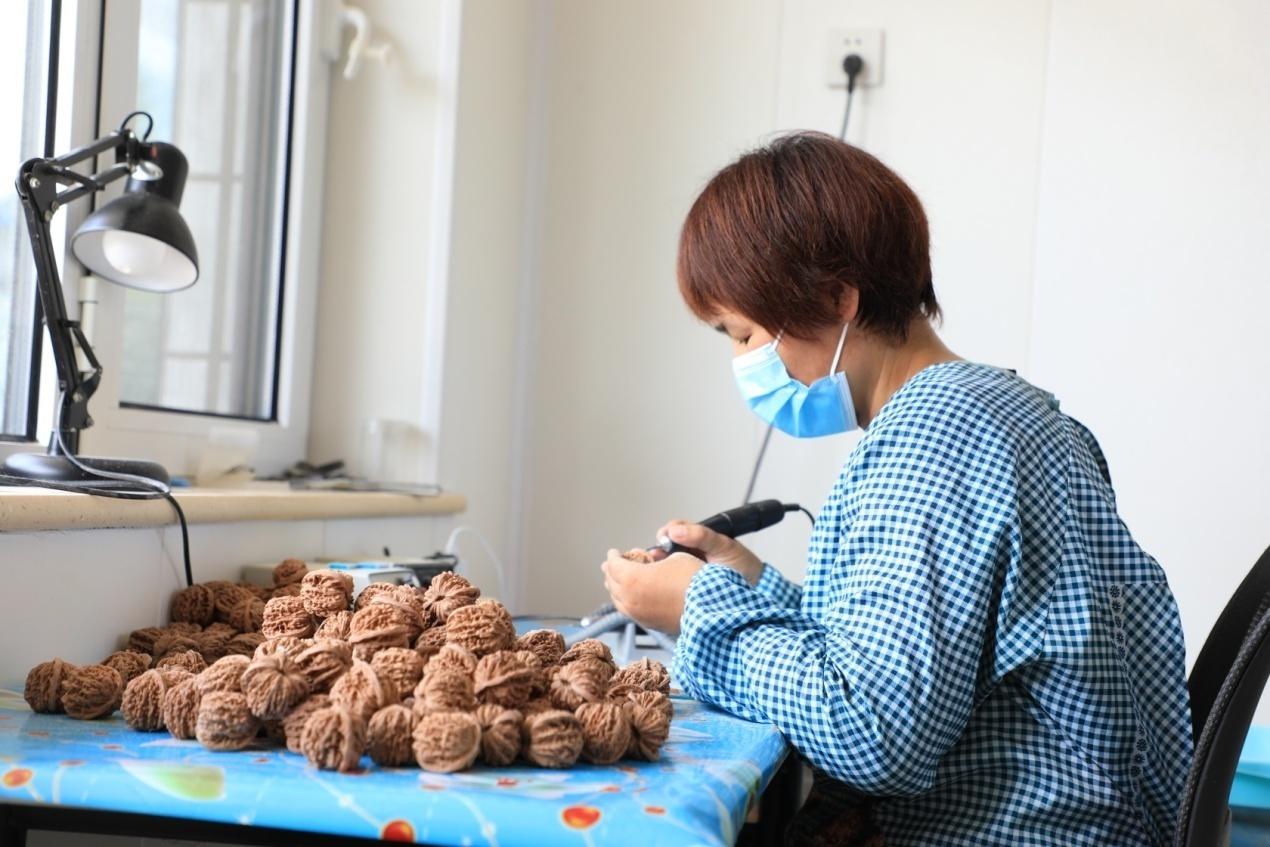 村民正在庭院内进行麻核桃修理工作。 贾晨阳摄