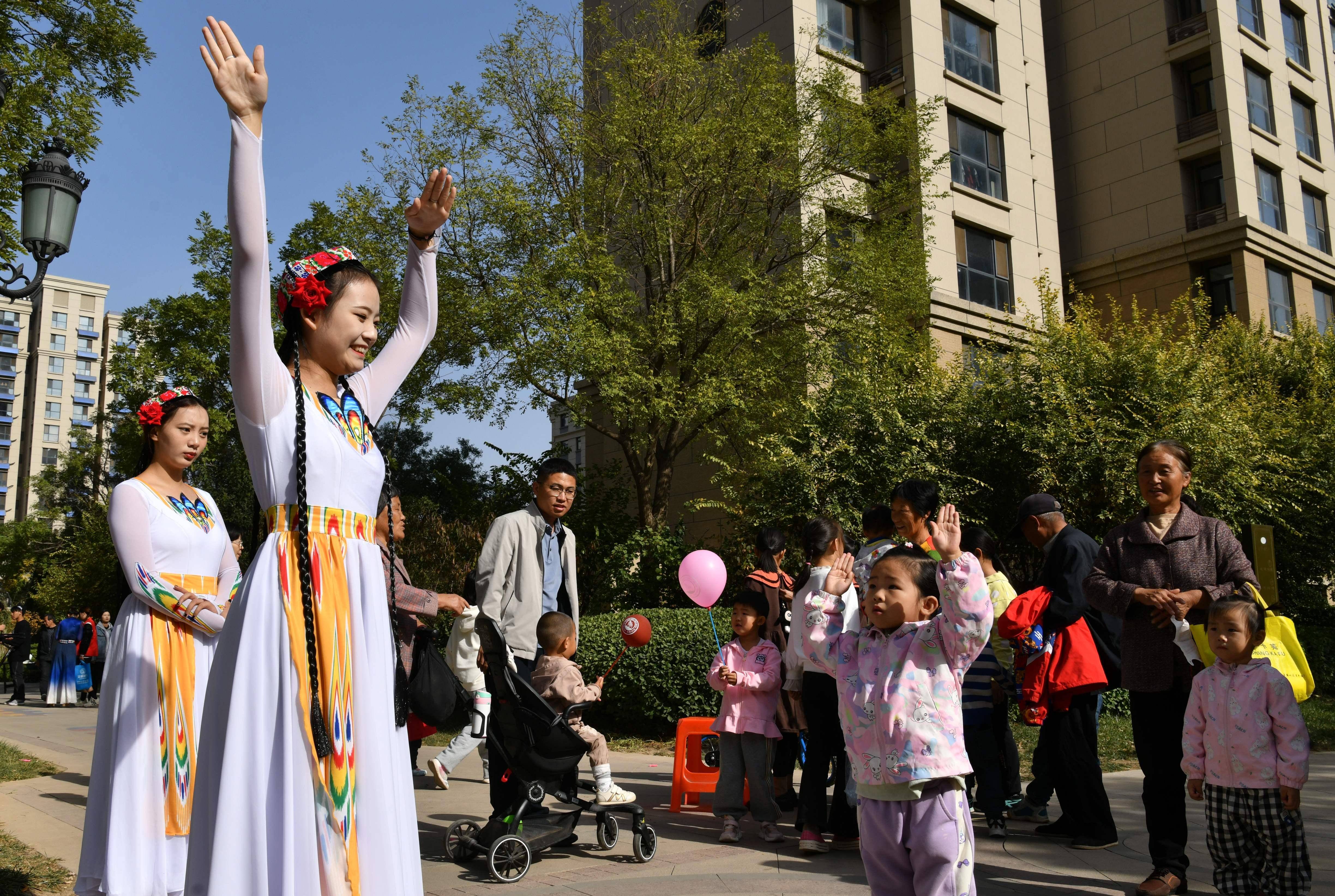11月4日，滄州師范學院學生在運河區亞龍灣社區教授小朋友學習民族舞。 苑立偉攝