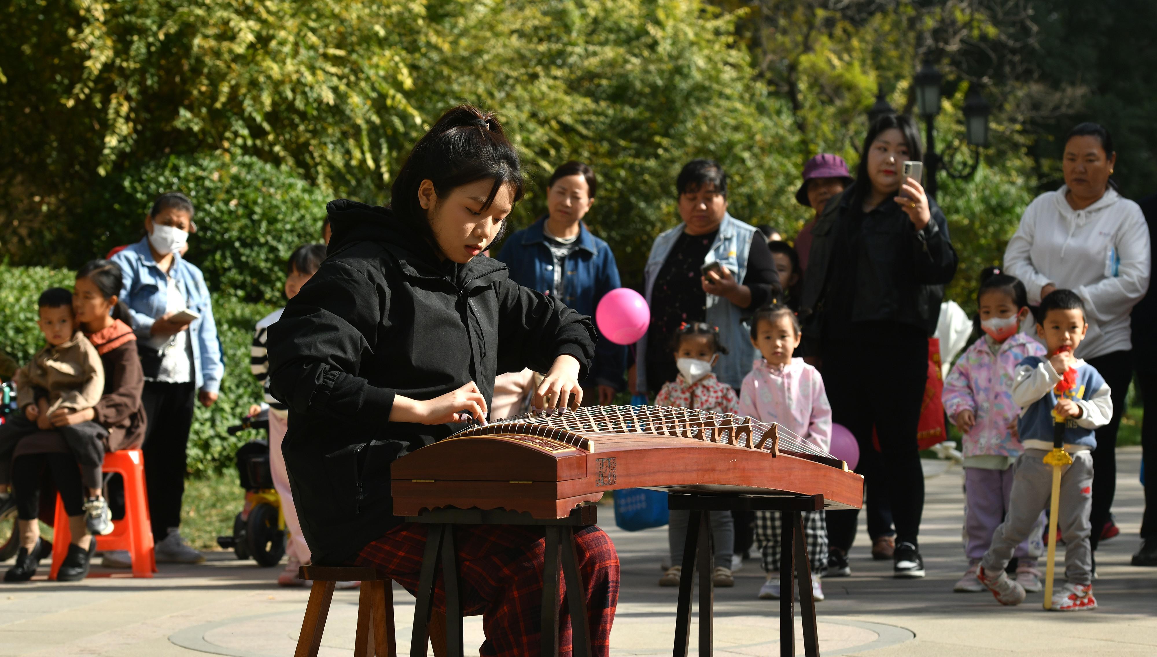 11月4日，沧州师范学院学生在运河区亚龙湾社区为居民演奏古筝。 苑立伟摄