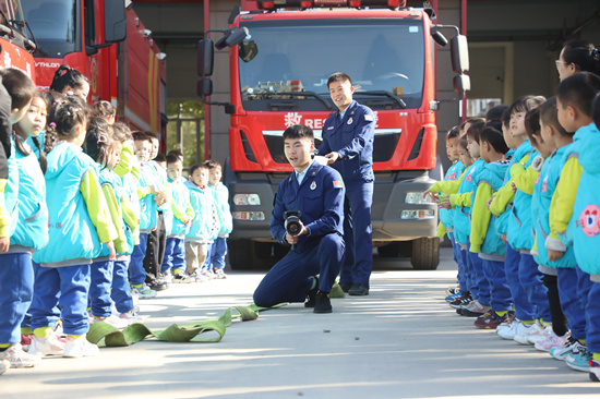 消防员向小朋友讲解救援器材使用方法。 李明摄