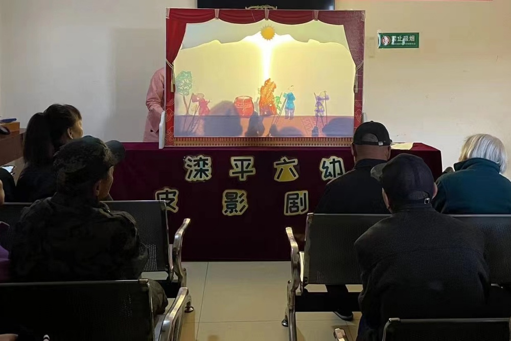 五保供養服務中心得老人們正專注的觀看小朋友們帶來的“皮影戲”表演。 徐靜攝
