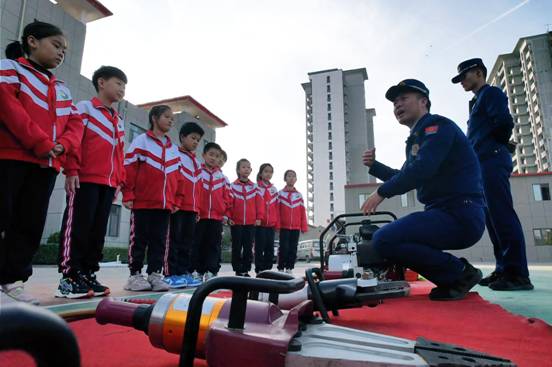 文安県消防救援大隊では、消防隊員が子供たちに各種消防機材を紹介している。鄭佳慶撮影