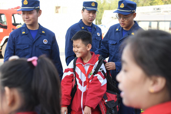 文安県消防救援大隊では、消防隊員が子供たちのために消防装備を着用している。郭小ボーリング