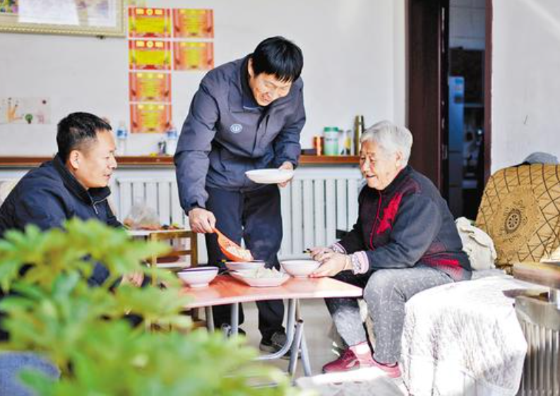 11月9日，涿州市小柳村駐村工作隊隊員在入戶走訪供暖准備情況時，為村民蔡玉仙（右一）送來熱氣騰騰的餃子。蔡玉仙今年80歲，她說房子修好了，還加了保溫層，過冬一定暖和。 河北日報記者 趙威攝
