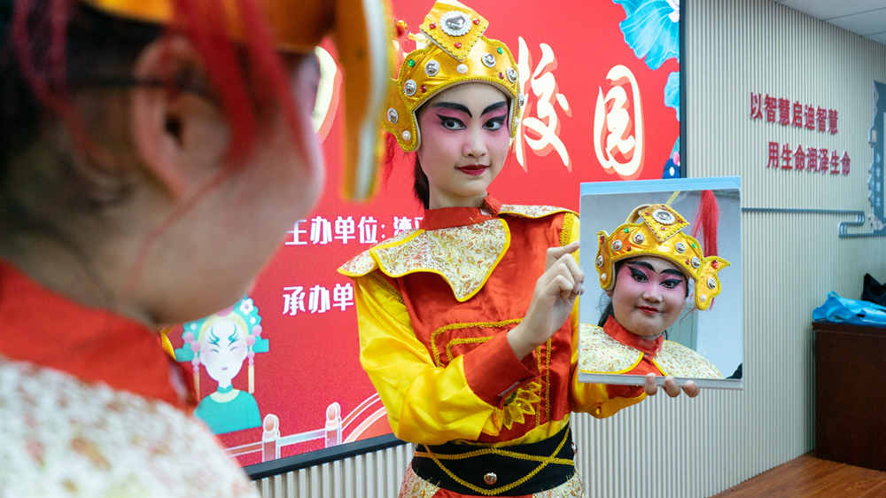 近日，在灤平縣第三小學，學生對著鏡子查看自己的戲曲裝扮。 梁志青攝
