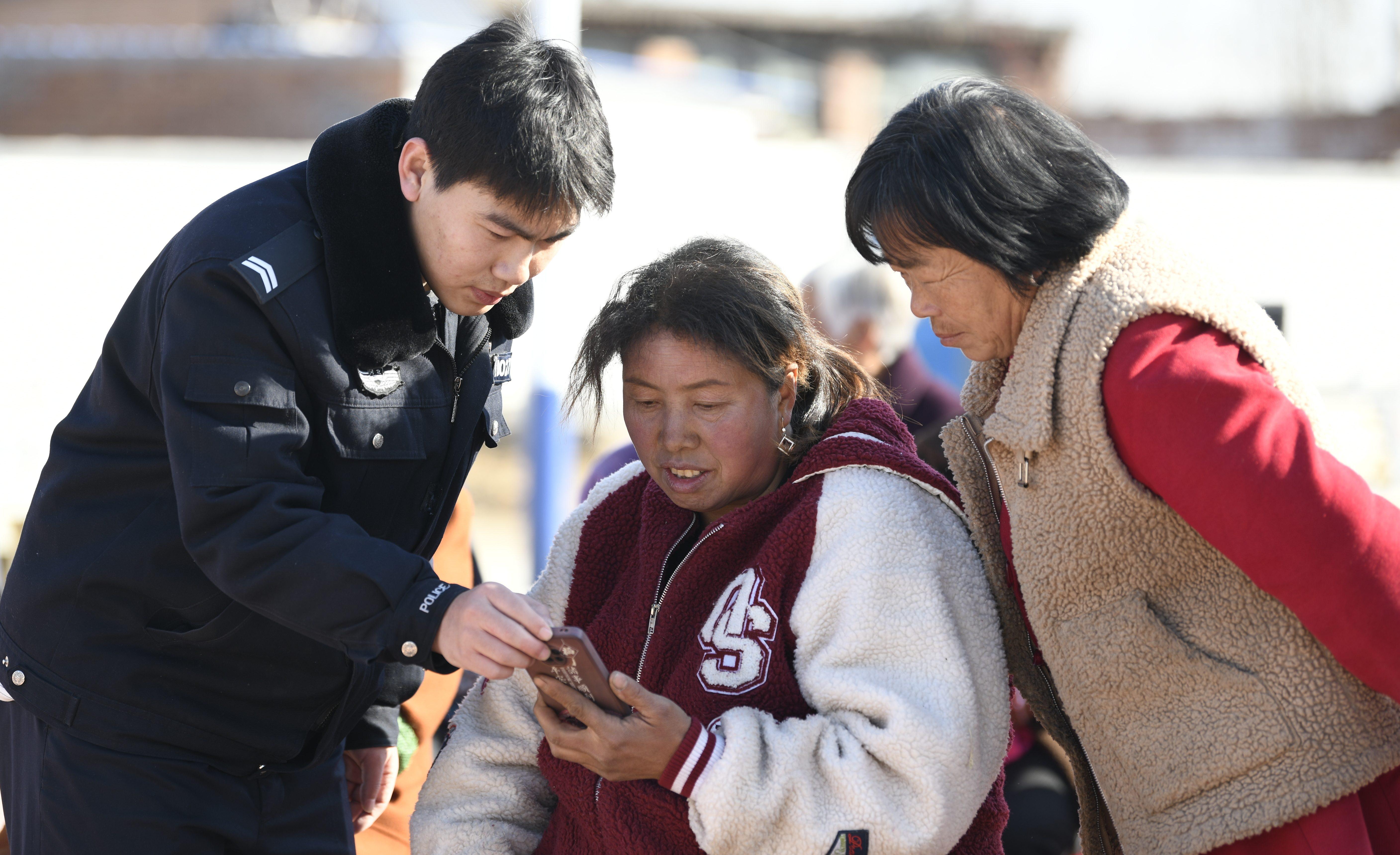 民警手把手指導村民安裝“國家反詐中心”APP。 梁玉水攝