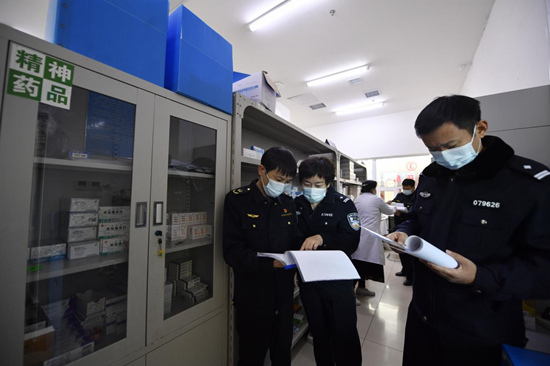 11月17日、文安県中医病院の外来薬局で、現地麻薬取締局と市場監督管理局の職員が精神系医薬品の処方箋登録状況を調べている。王暉撮影