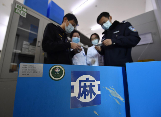 11月17日，在文安县中医院门诊药房，当地禁毒办和市场监管局工作人员正在查看麻醉类药品存储保管情况。王晖摄