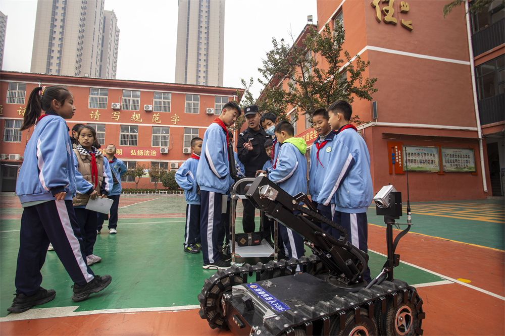 日前，河北省邯郸市公安局特警支队干警走进复兴区第二实验小学，开展警民共建安全教育活动，学生们在操作机器人排爆。 聂长青摄