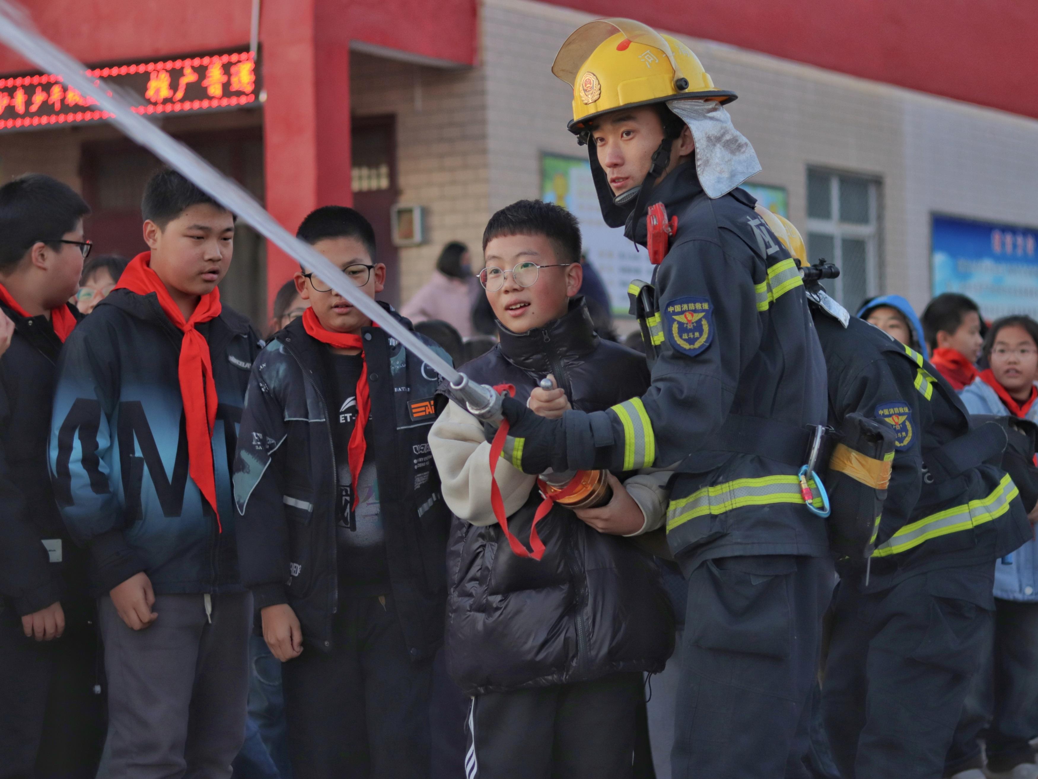 學生們體驗操作消防水槍出水。 張光偉攝