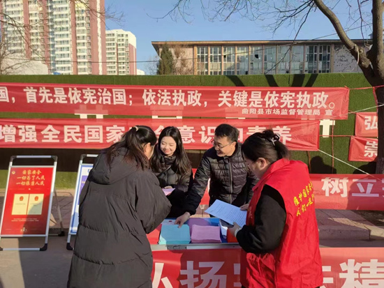 工作人员向群众发放宣传页，普及法律知识。曲阳县司法局供图