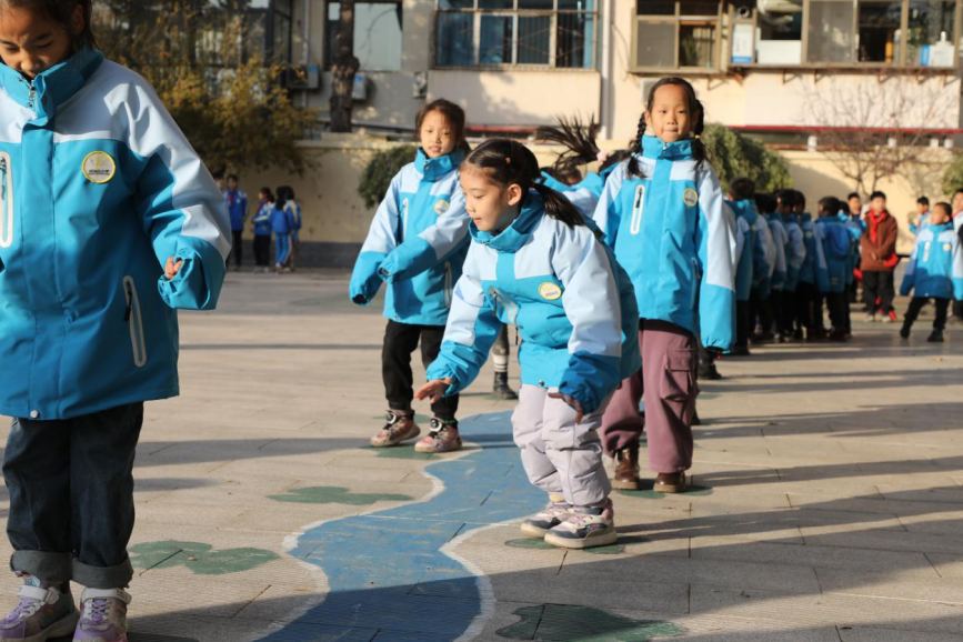 学生们在校园里画出的游戏活动区中蹦跳玩耍。 吴梦莹摄