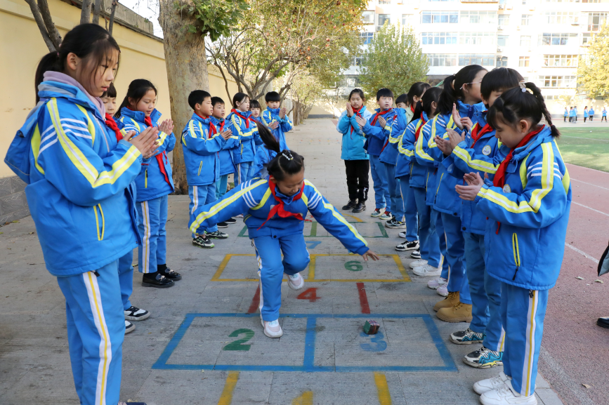 石家庄市橋西區城角街小學校園裡畫出傳統游戲活動區，學生們聚在一起跳房子做游戲。 吳夢瑩攝