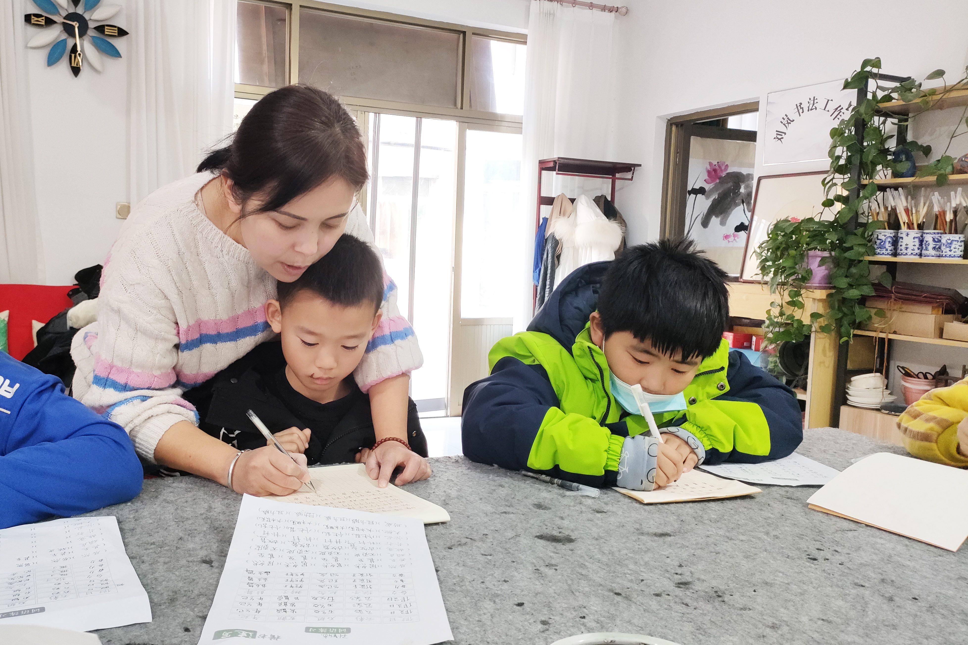 12月6日，老师指导孩子握笔姿势。 吕钧山摄