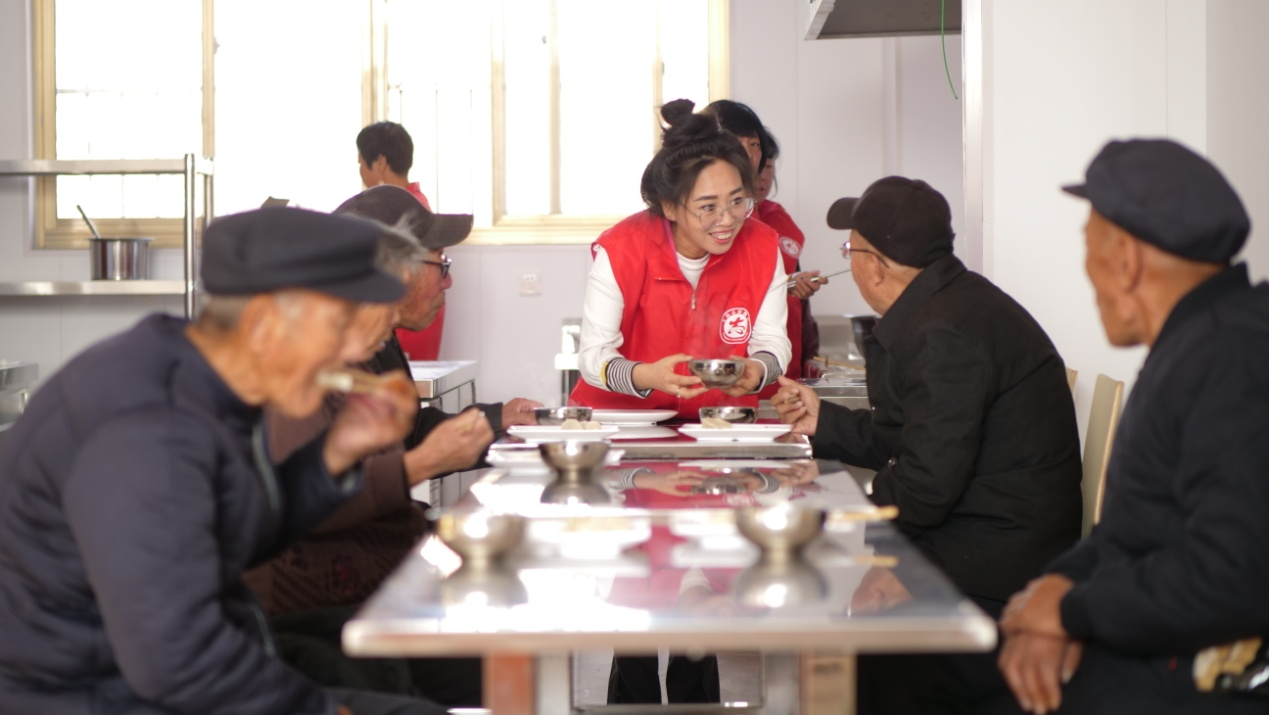 志愿者们为老人送上爱心水饺。 崔光摄