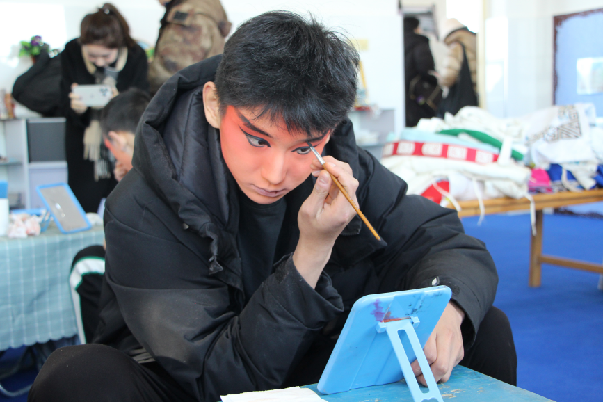 近日,在高陽縣河西村小學,保定藝術學校學生演出前化妝。 楊瀰攝