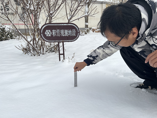 12月11日清晨，徐水区气象局工作人员在测量积雪厚度。 王双摄