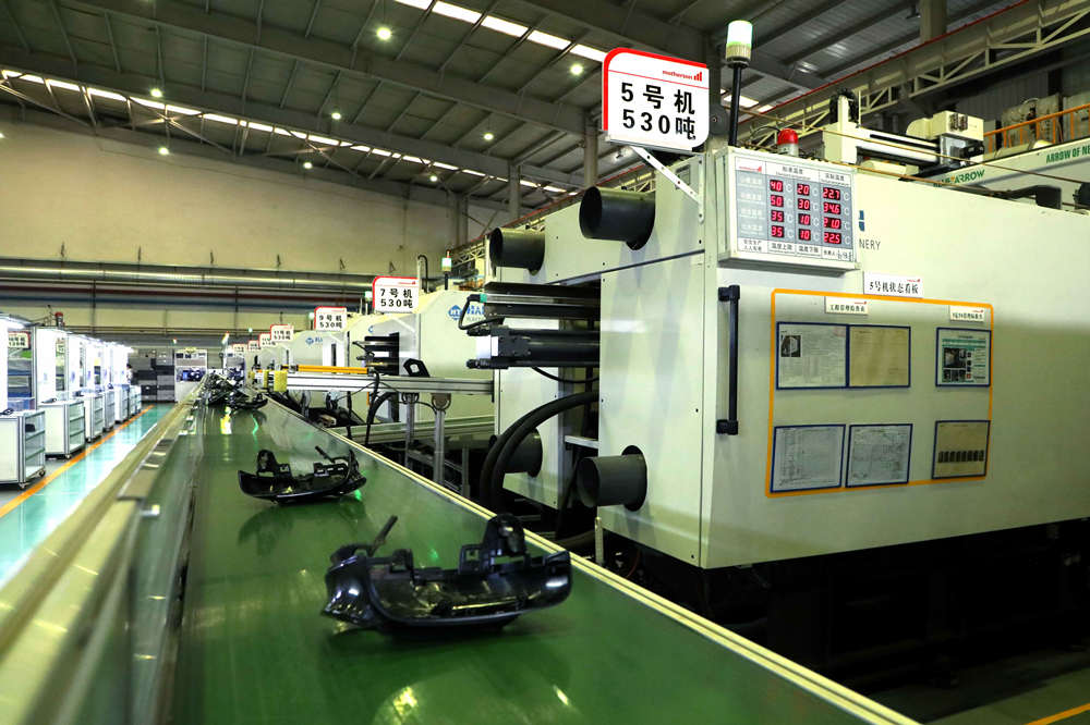 赛铭瑞汽车零部件(廊坊)有限公司注塑车间,原材料被投入到注塑机内,生产后视镜外壳。 陈宏儒摄